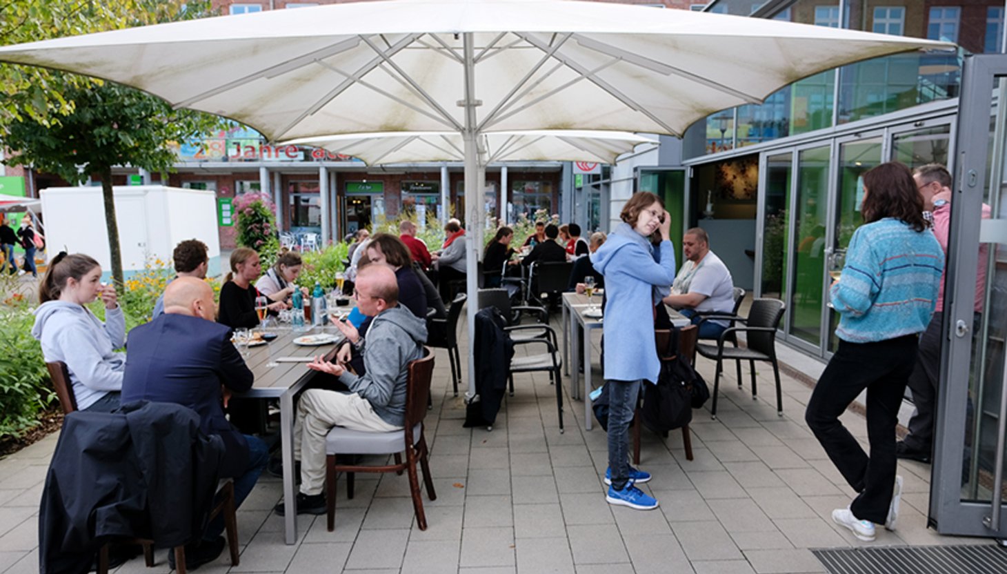 Das Team von GUT GEFRAGT auf einer Terrasse an mehreren Tischen.